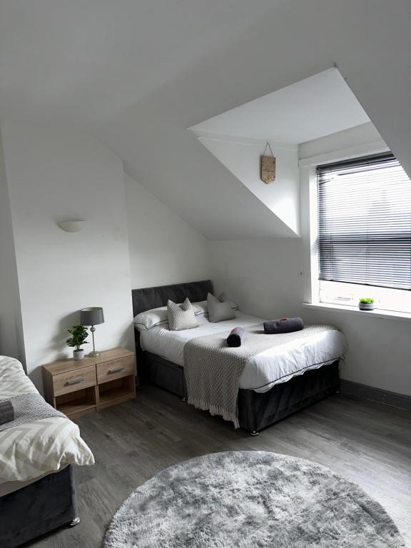 a bedroom with two beds and a window at Budget Rooms Lincoln City Centre , Fast WiFi & Self Check in in Lincoln