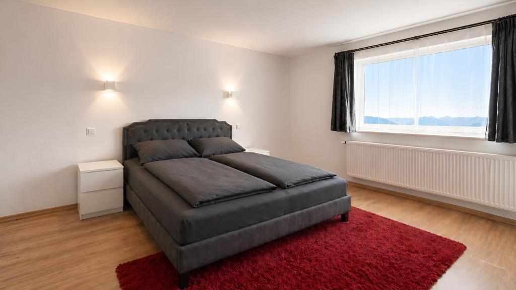 a bedroom with a large bed and a red rug at Apollo Home - Zuhause in der Natur! in Wildflecken