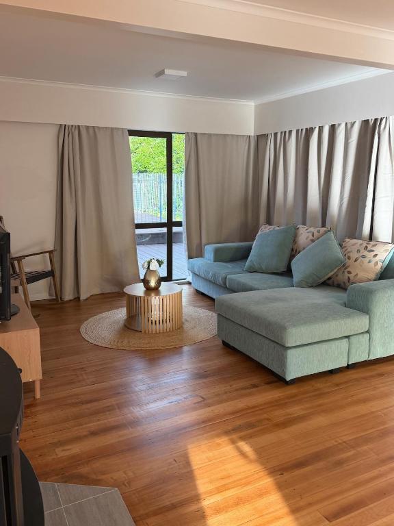 a living room with a couch and a table at Otaihanga Getaway in Paraparaumu