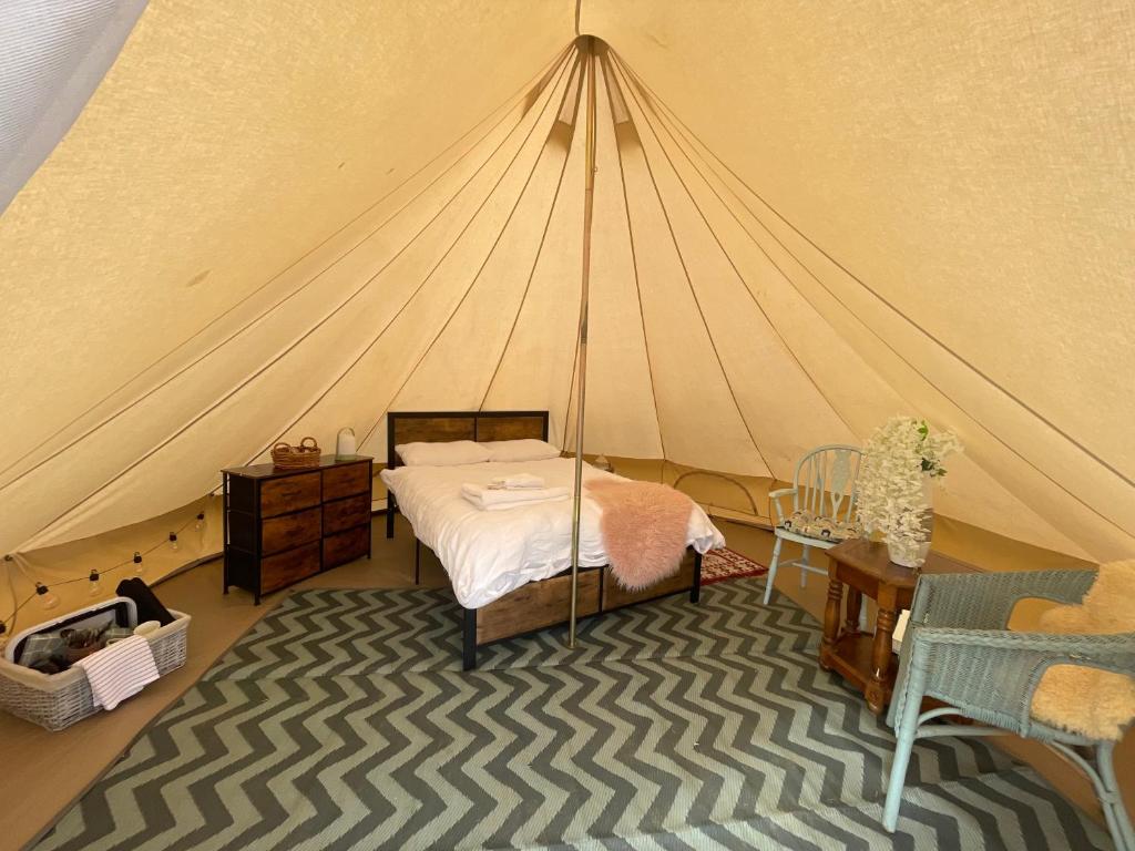 a bedroom with a bed in a tent at Country PUPkins Camping in Branscombe