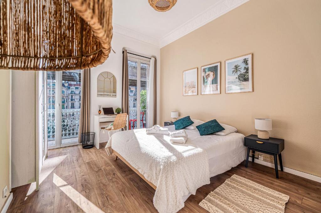 a bedroom with a bed and a large window at Chambre 1 Lou Calan in Nice