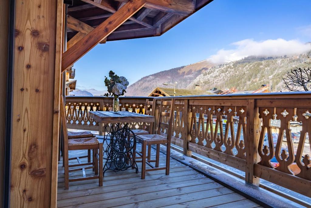 a wooden balcony with a table and chairs on it at Morzine Centre Apartment 1 min from Super M in Morzine