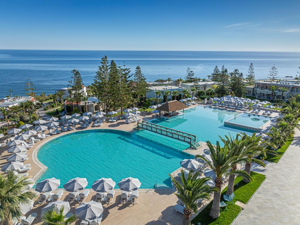 an overhead view of a swimming pool with umbrellas and the ocean at Iberostar Selection Creta Marine in Panormos Rethymno