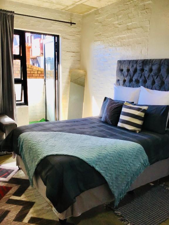 a bedroom with a large bed with a blue comforter at Home at heart in Johannesburg