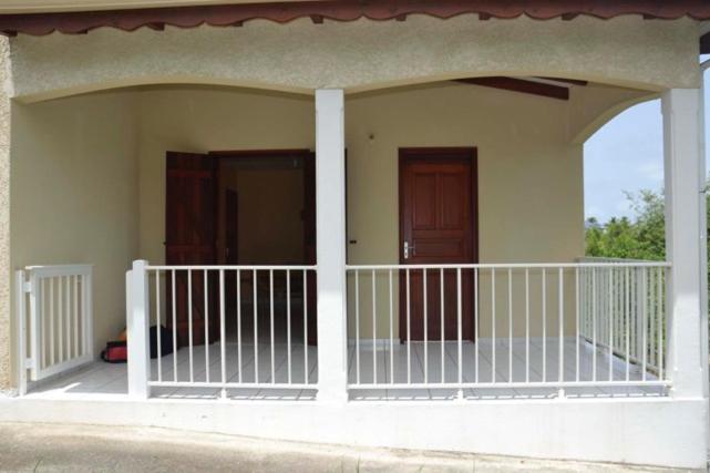 eine Veranda an einem Haus mit zwei Türen in der Unterkunft Casa Sergio in Le Moule
