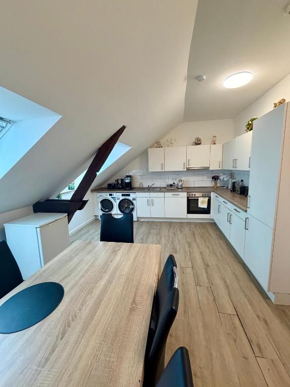 a large kitchen with white cabinets and a table at Business Unterkunft Balje 567 - Monteur- & Ferienwohnung mit 7 Einzelbetten in Balje