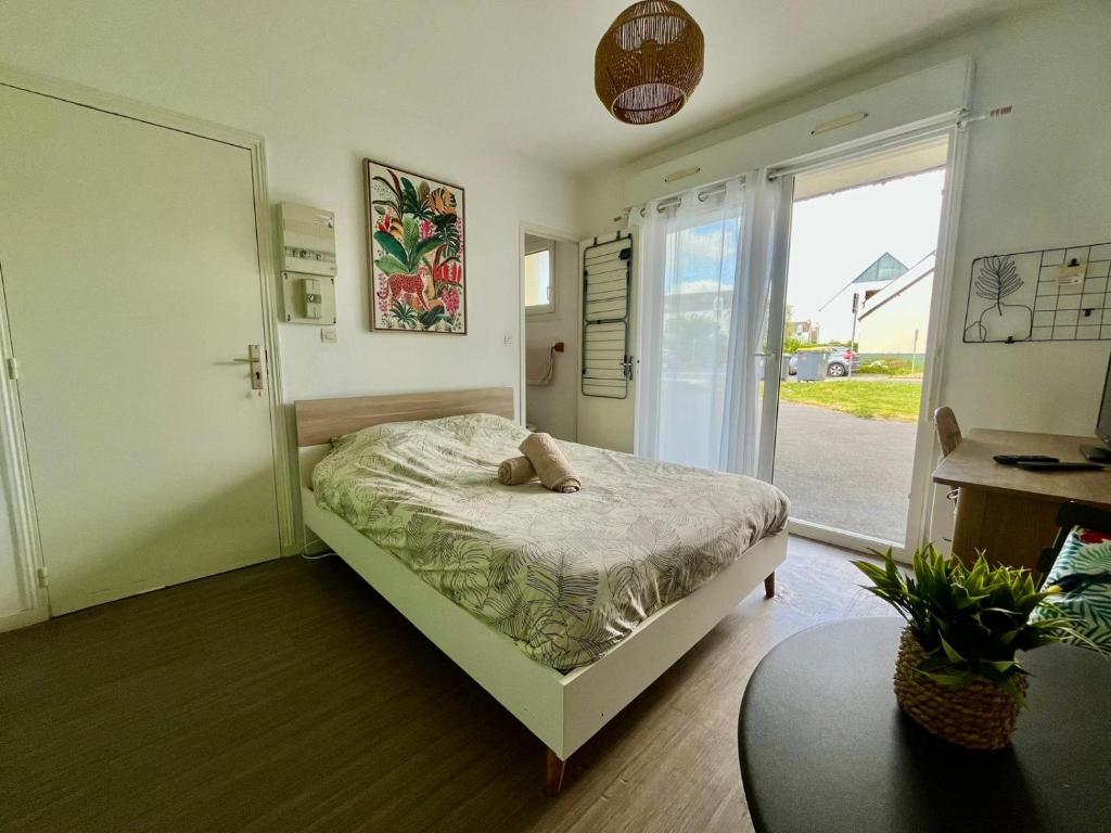 a bedroom with a bed with a teddy bear on it at Le Ptit Germain in Saint-Germain-la-Blanche-Herbe