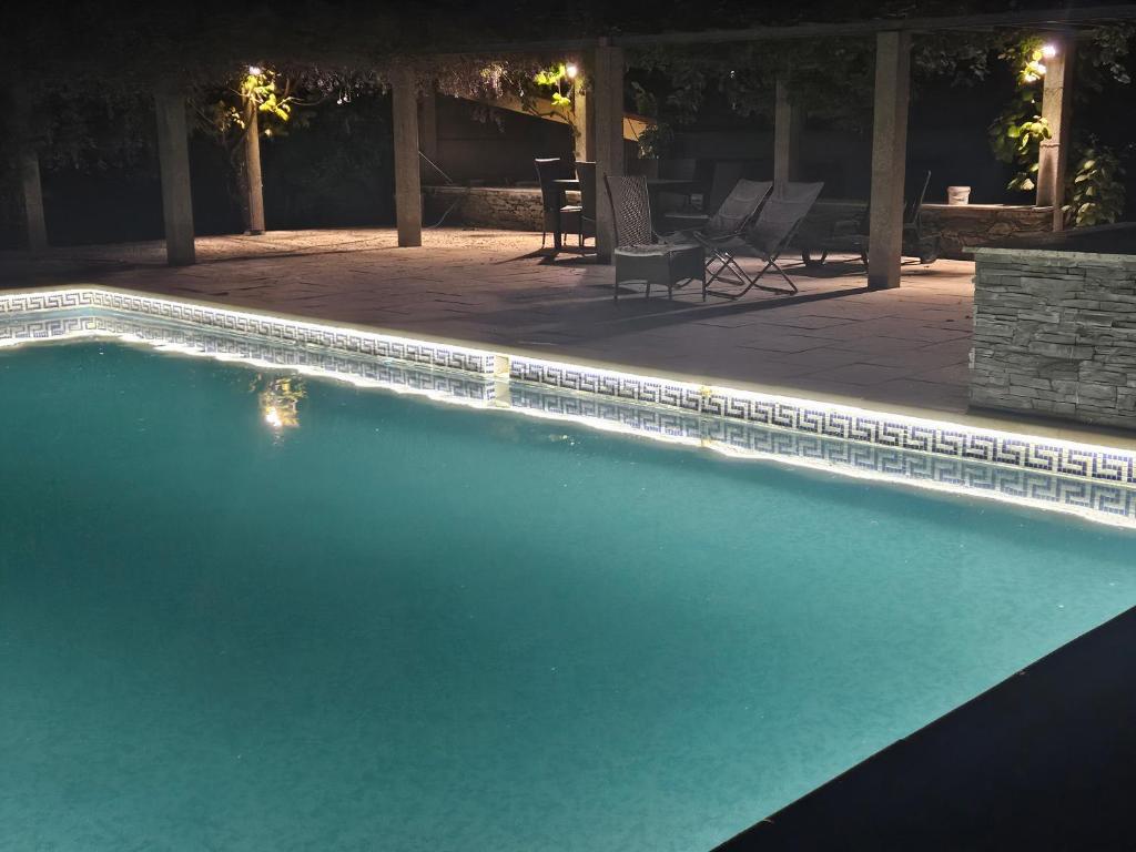 a swimming pool at night with chairs and a patio at Quinta do Adil in Macedo de Cavaleiros