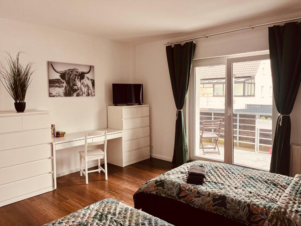 a bedroom with a bed and a desk with a cow on the wall at Gästehaus Gerschler in Garbsen