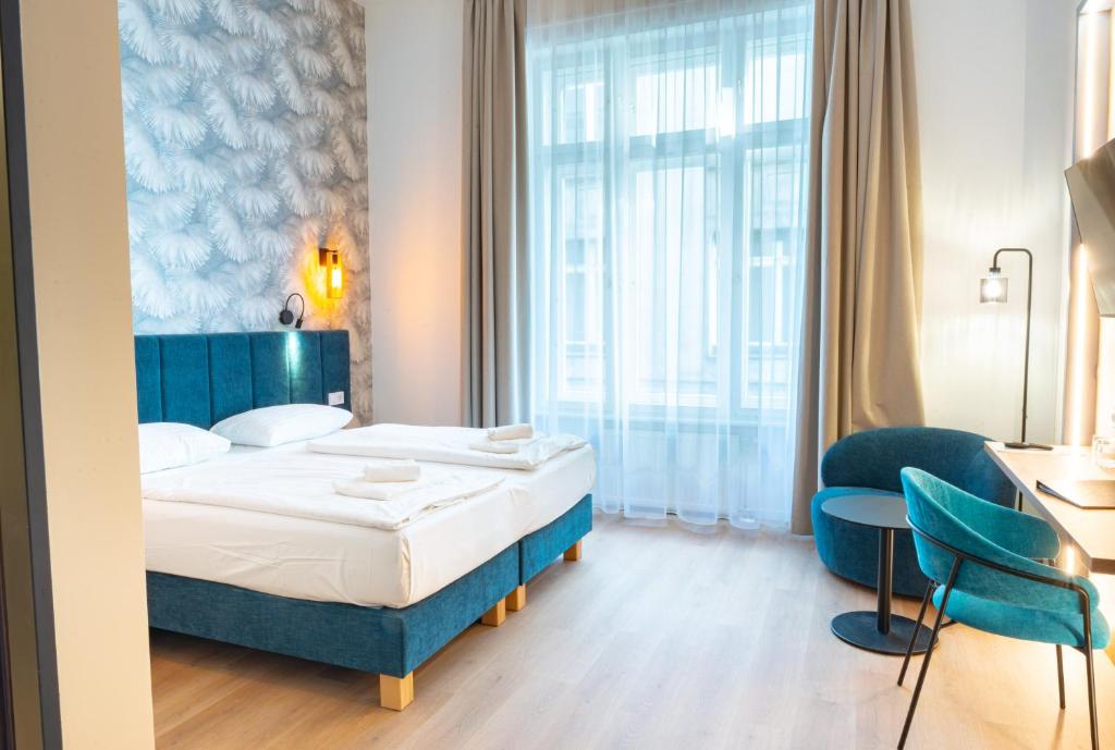 a hotel room with a bed and a table and chairs at Pilvax Hotel Budapest in Budapest