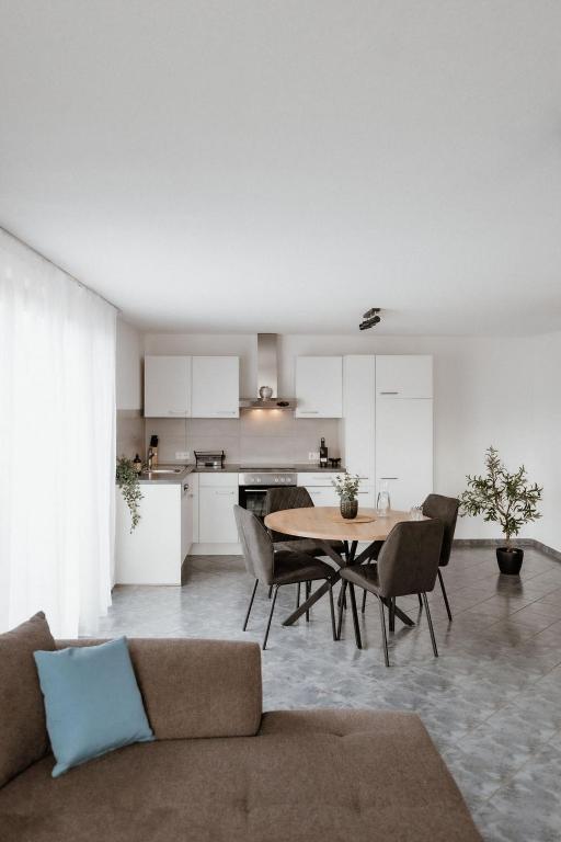 a living room with a table and chairs and a kitchen at Riedwohnung 2 in Lustenau