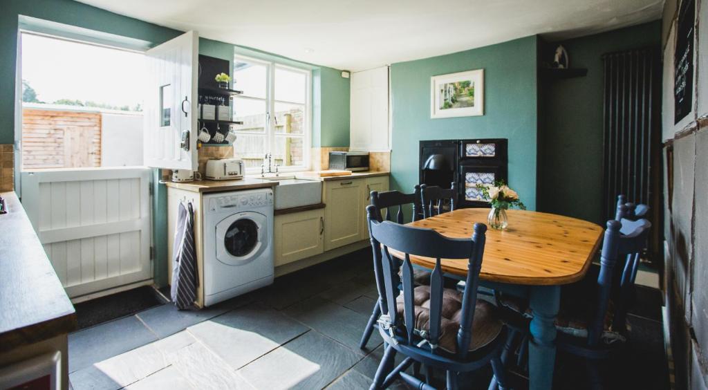 a kitchen with a table and a washing machine at No.8 Accommodation in Chepstow
