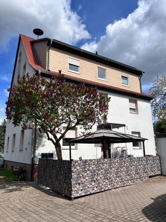 a building with a tree and an umbrella in front of it at Ferien- und Monteurwohnungen Andrej in Eisenach