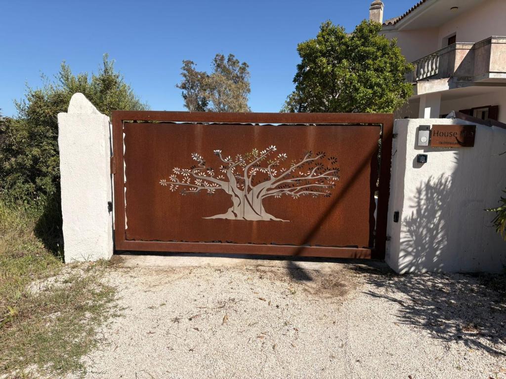 a gate with a tree etched into it at House Mia in Cala Liberotto