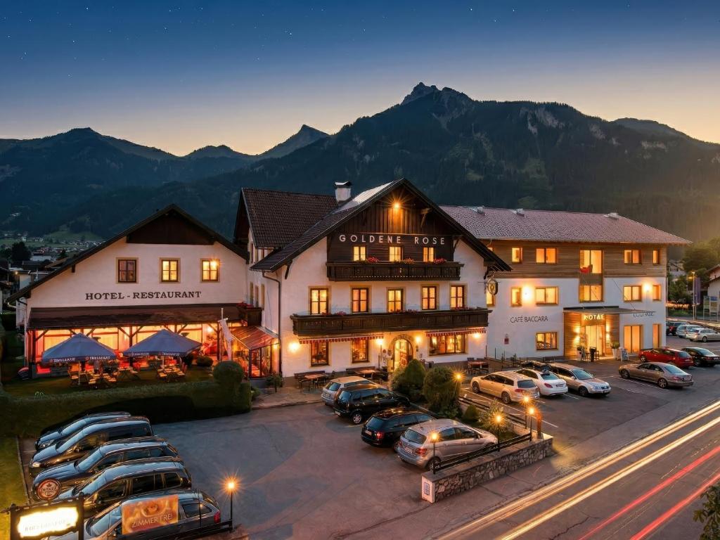 a large building with cars parked in a parking lot at Hotel Goldene Rose in Reutte