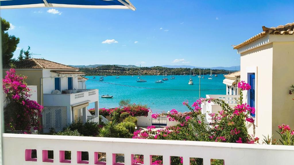 a view of the water from a balcony with flowers at Pink Villa in Porto Heli