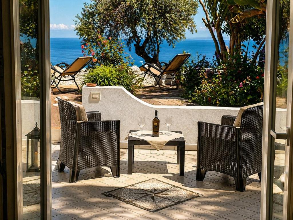 a table and chairs with a bottle of wine on a patio at Barracuda Suite Sea View & Dinner Experience in Ischia Town