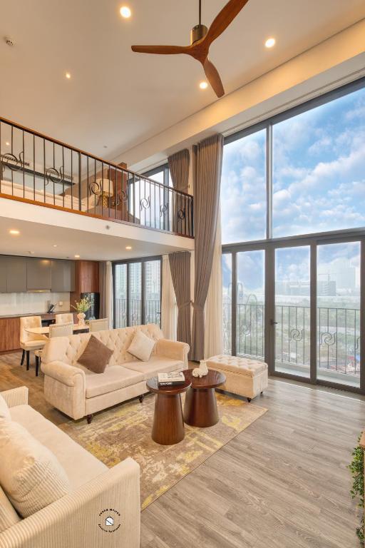 a living room filled with furniture and a large window at Luxury Duplex & Apartment Pentstudio - Tay Ho Hanoi in Hanoi