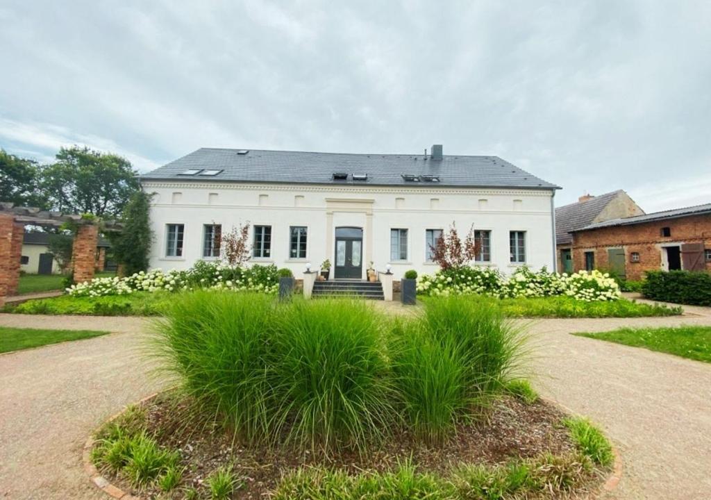 a large white house with a yard with plants at 9-Personen-Fewo - viel Platz für Familien, Gruppen & Seminare in Buchholz
