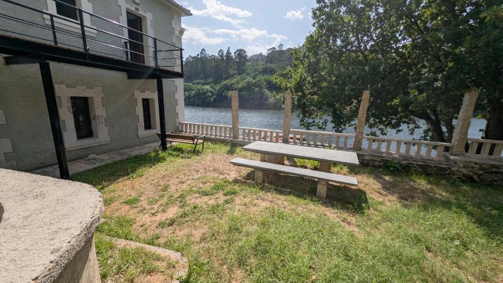 a bench sitting in the grass next to a building at Casa rural A Fonte, Balneario Histórico de Cortegada in Cortegada