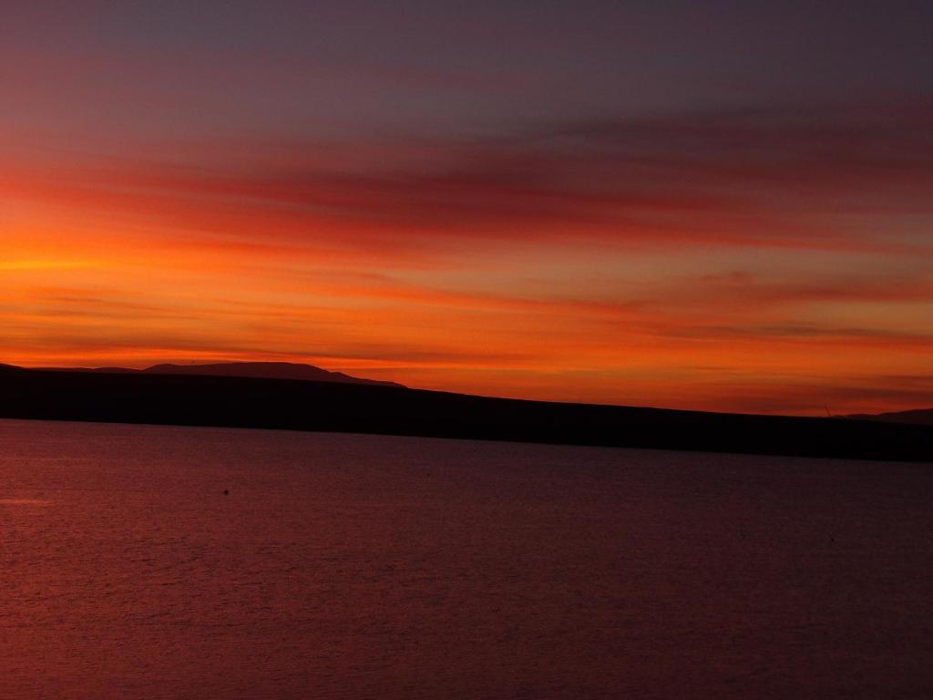 a sunset over a body of water at Vestley Banks in Orkney