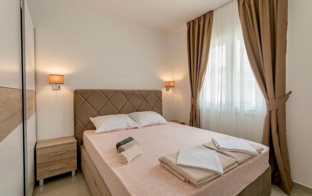 a bedroom with a bed with two towels on it at Apartmani Coka in Sušćepan
