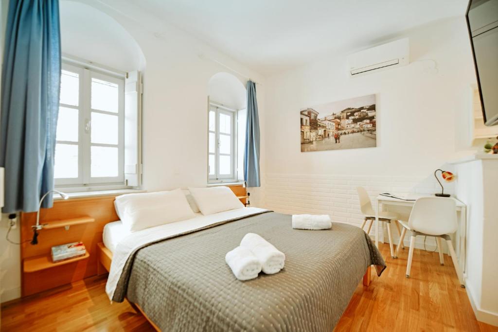 a bedroom with a bed with two towels on it at Hydra's Ruby in Hydra