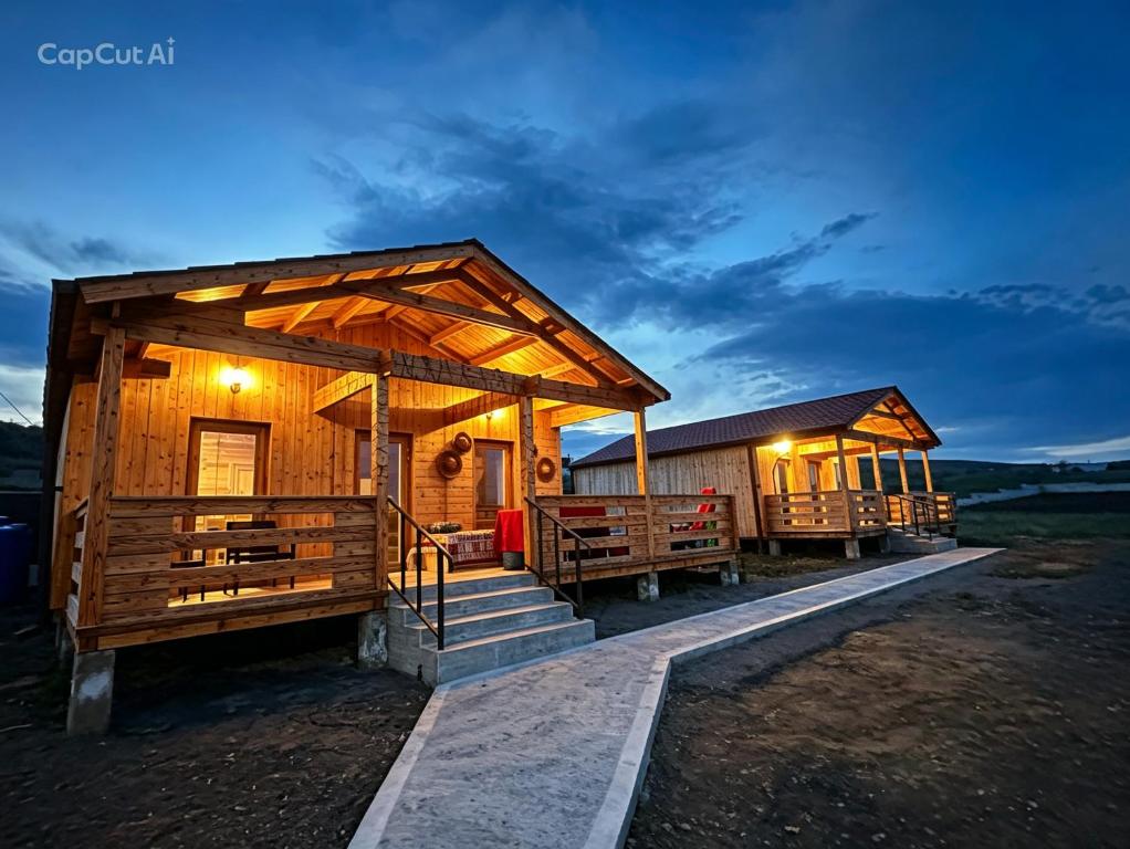 a log cabin with a porch and stairs to it at chemtan cottages in Dushetʼi
