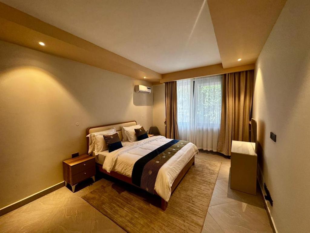 a hotel room with a bed and a window at Masaki Cozy Stay in Dar es Salaam