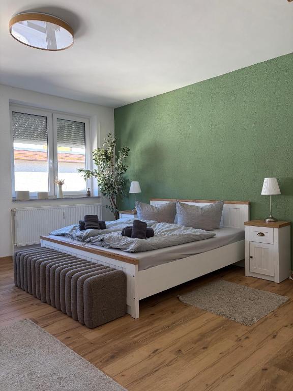 a large bed in a room with a green wall at Feriennest am Meer Warnemünde in Warnemünde
