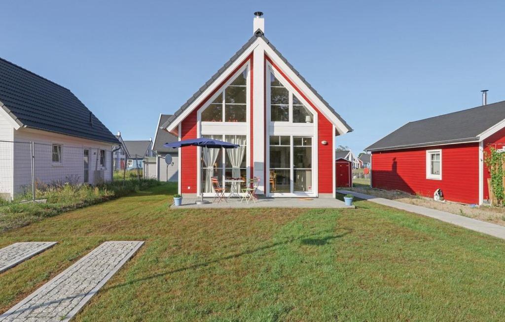 a red house with a frisbee in the yard at Haus Hallon in Wandlitz