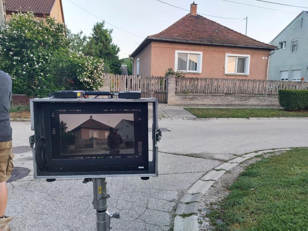 a tv on a pole in a street with a house at Nagyiék háza / Granny's House in Esztergom