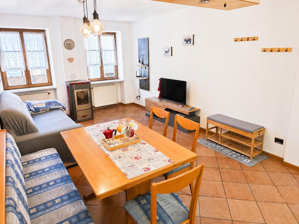 a living room with a table and a couch at ElvesHome - Alpine Stay Apartments in Predazzo