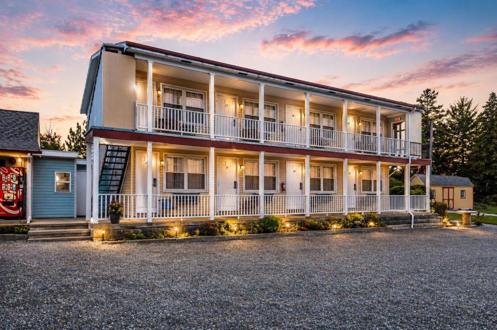 a large white building with a sunset in the background at OYO Hotel Starlite Seneca Falls in Seneca Falls