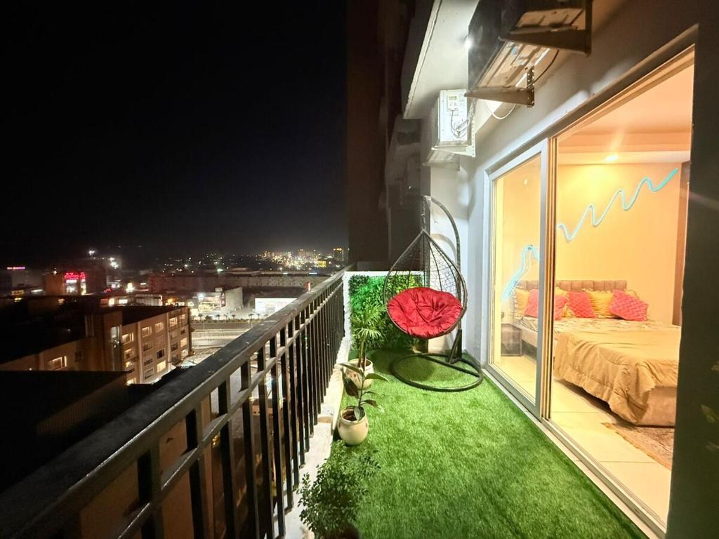 a balcony with green grass and a bed on it at Vetri Homes IV in Zirakpur