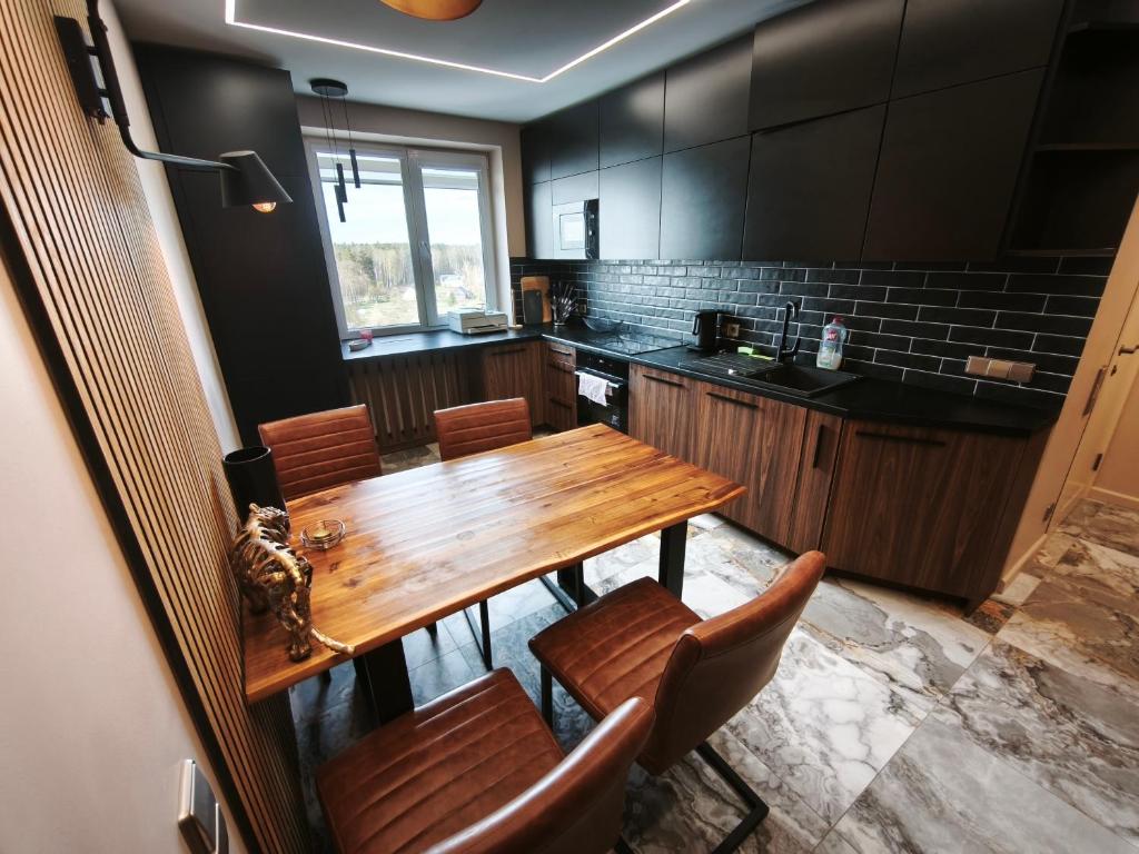 a kitchen with a wooden table and chairs at Panorama View Suite in Jelgava