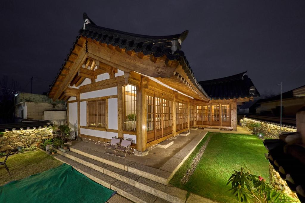 a house with a pavilion in the yard at night at Hanok Moonstay in Gyeongju