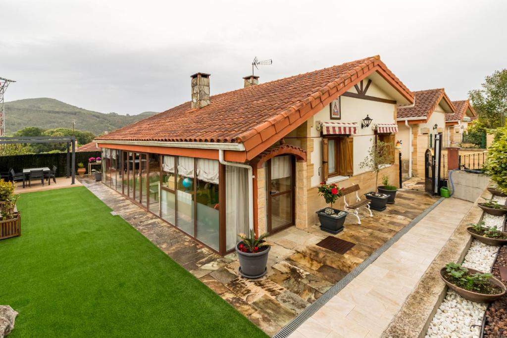 a house with a yard with green grass at Las Camelias in Argoños