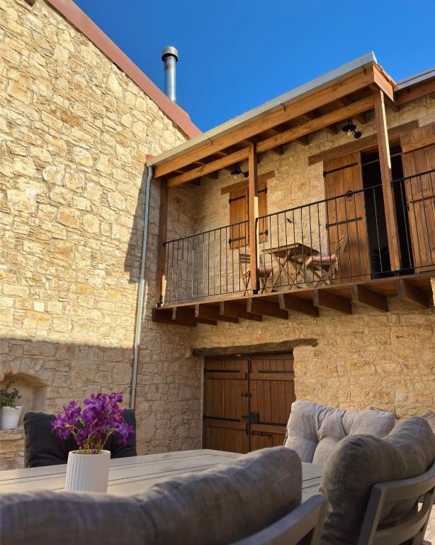 a patio in front of a brick building with a balcony at Eftychia's House in Lofou