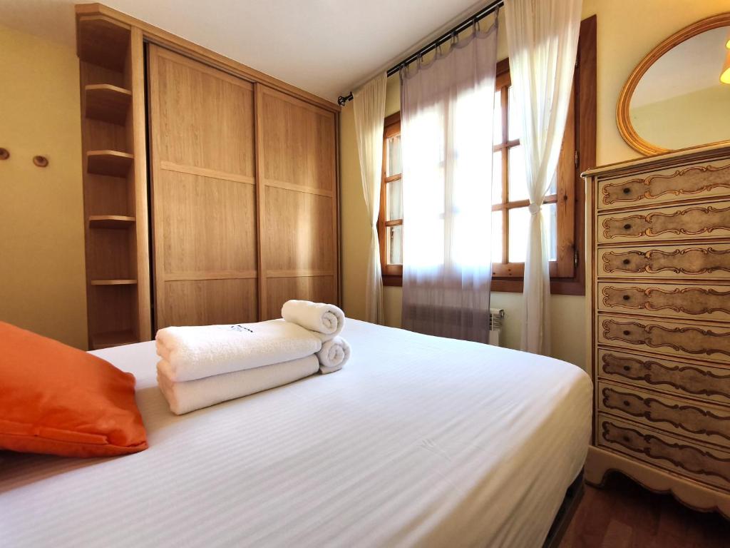 a bedroom with a bed with towels on it at AC Apartaments Canillo in Canillo