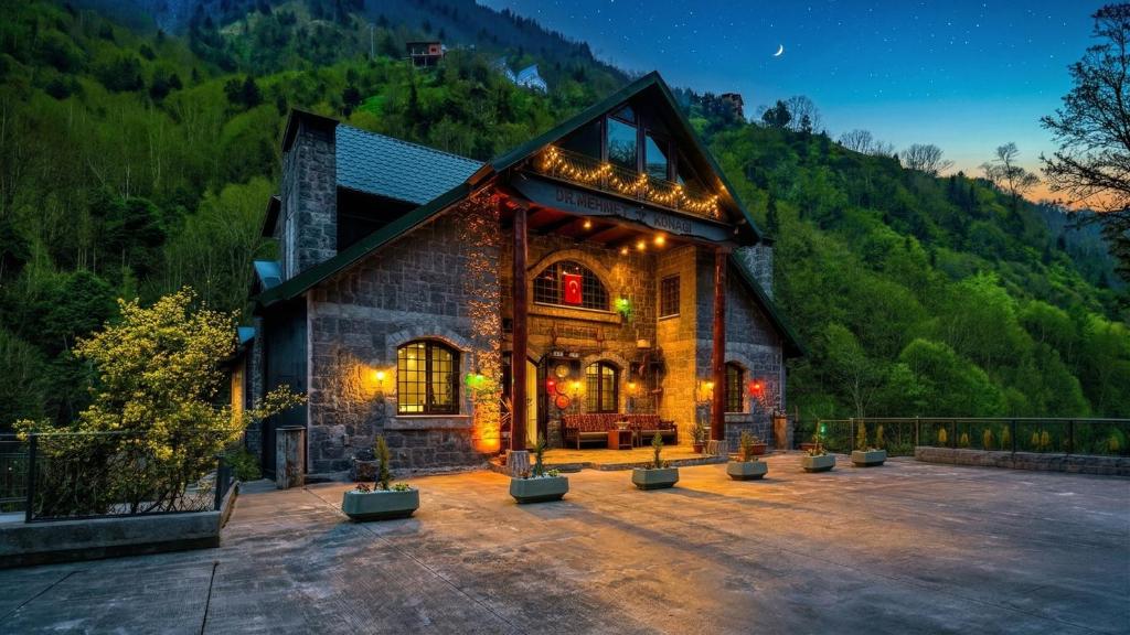 a house in the mountains with lights on it at Elikti Otel in Ardeşen
