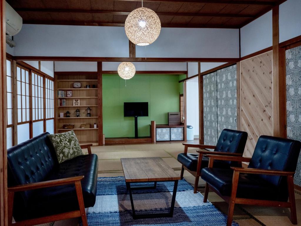 a living room with two chairs and a table at 一棟貸しの宿 Granny and the sea グラニーアンドザシー in Shima