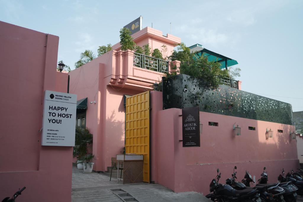 a pink building with motorcycles parked in front of it at Artistik Abode by Stay Banaras in Varanasi