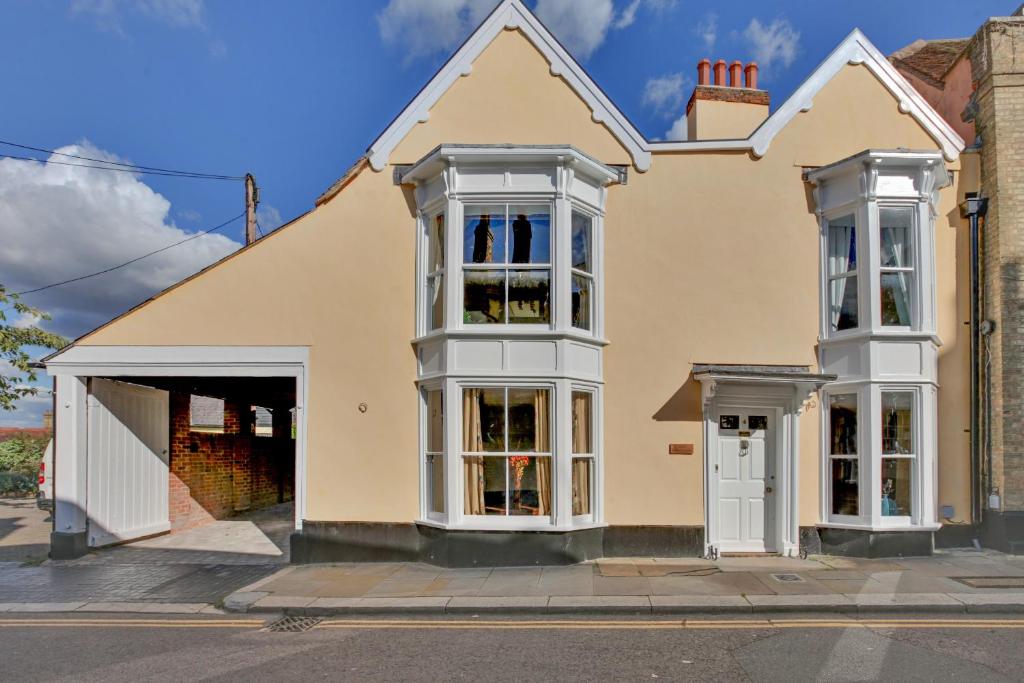a yellow house with white windows and a garage at Finest Retreats - Josua, Maldon in Maldon