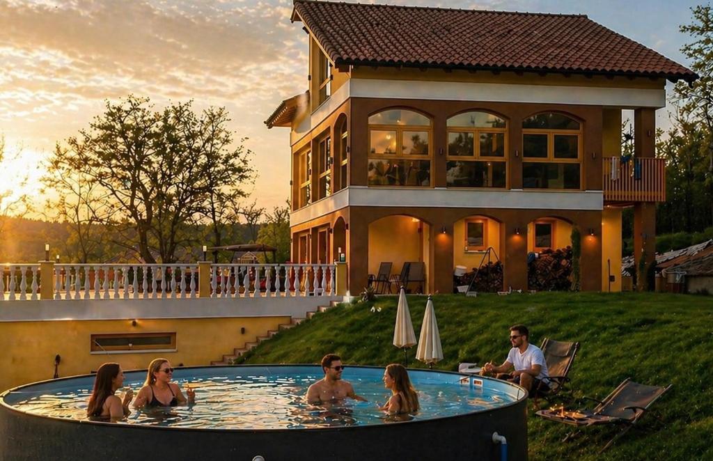 a group of people in a pool in front of a house at VILLA BEELVITA - PRIVATE POOL& JACUZZi in Bielovce