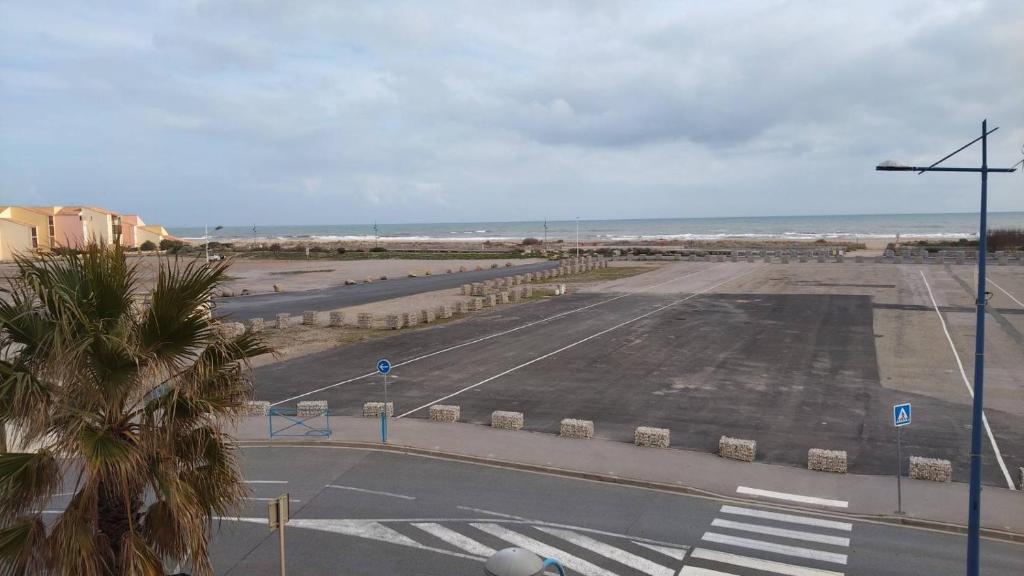 an empty parking lot next to the beach at Appartement balcon proche mer in Saint Pierre La Mer