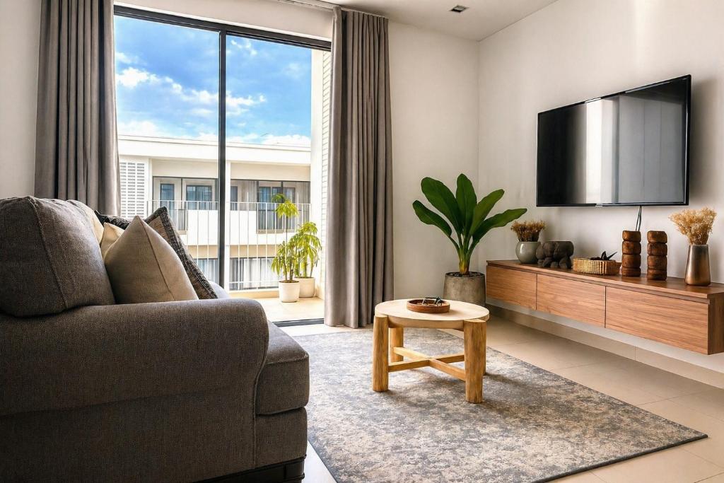 a living room with a couch and a flat screen tv at Rose & Golf at Rose Apple Square in Siem Reap