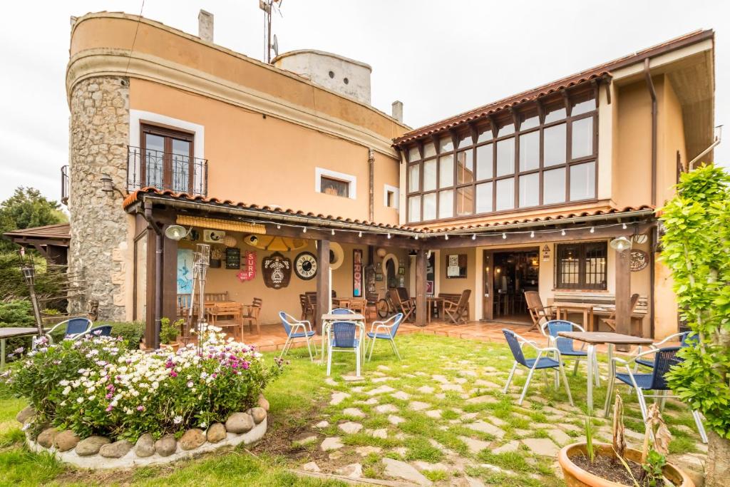 a building with chairs and tables in a yard at Casa Del Surf Somo in Somo
