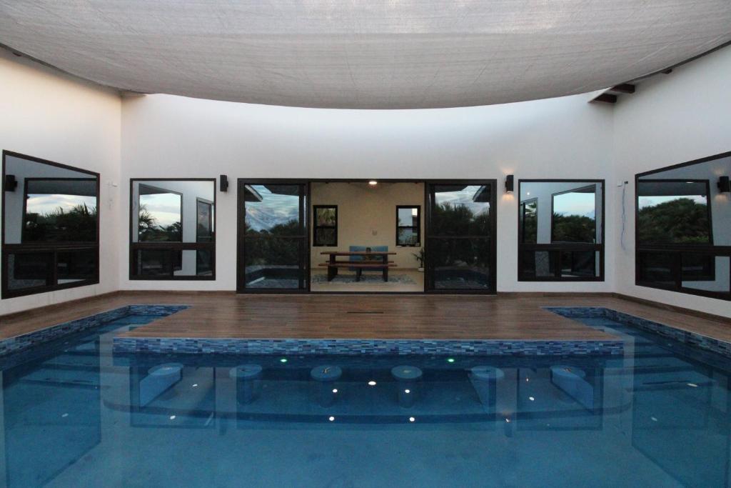 a house with a swimming pool with glass windows at Sunset Oasis Waterfront in Maya Beach