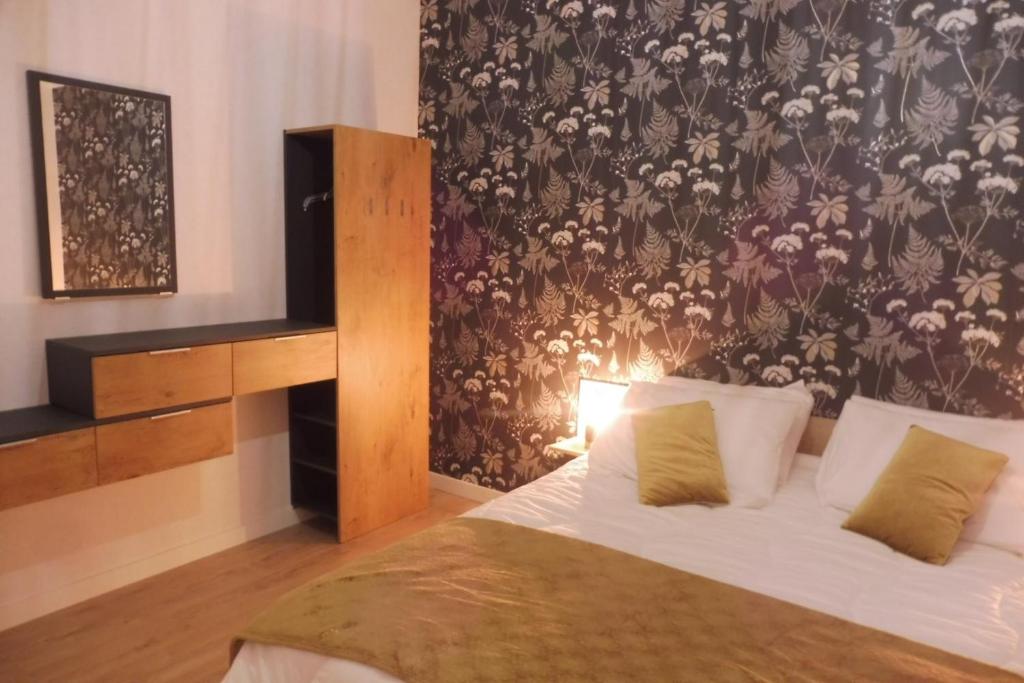 a bedroom with a bed with a floral wallpaper at Le Gîte Du Vigneron in Saulcet